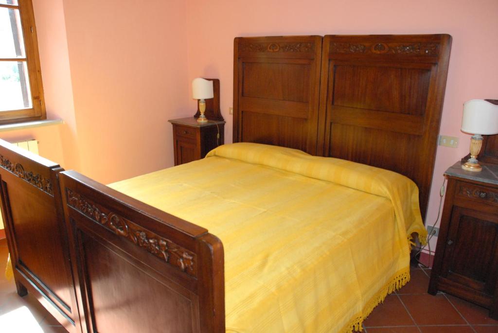 1 dormitorio con 1 cama con colcha amarilla en La Carpinella, en Montone