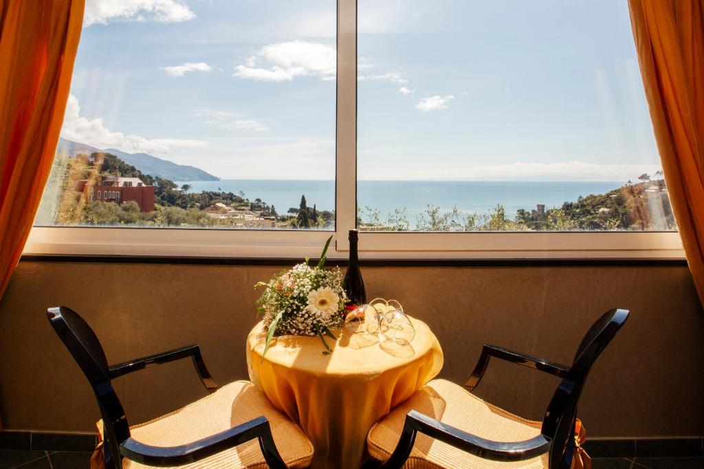 a table with chairs in front of a large window at B&B Il Parco in Monterosso al Mare