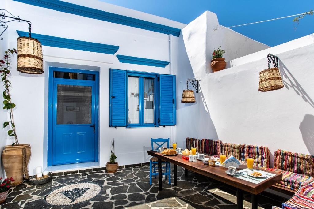 een eetkamer met blauwe deuren en een tafel en stoelen bij Koskinou Traditional Houses in Koskinou