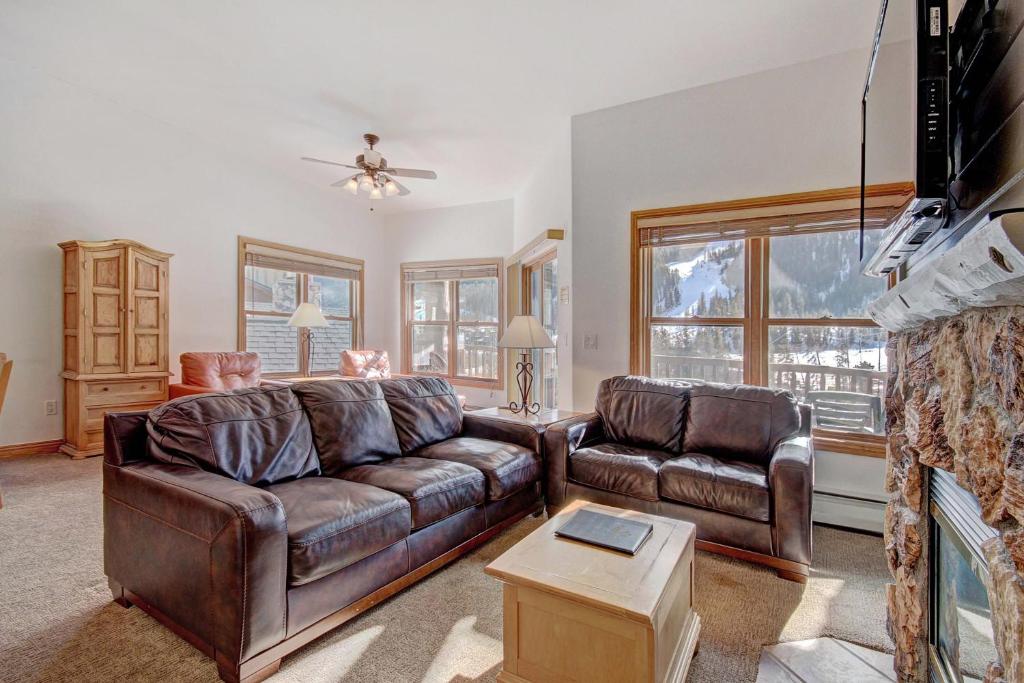 salon z 2 skórzanymi kanapami i kominkiem w obiekcie 5983 Hidden River Lodge Condo w mieście Keystone