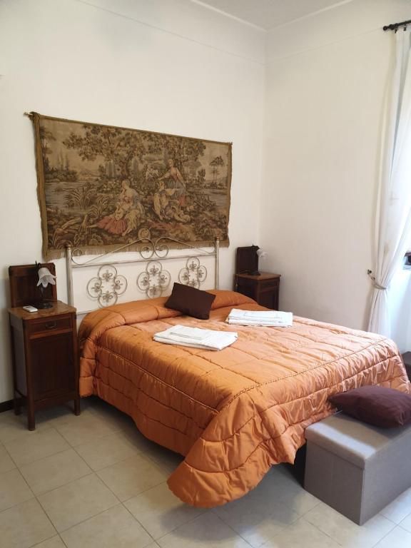 シラクーサにあるMaestranza Holidayのベッドルーム1室(オレンジ色の掛け布団付きのベッド1台付)