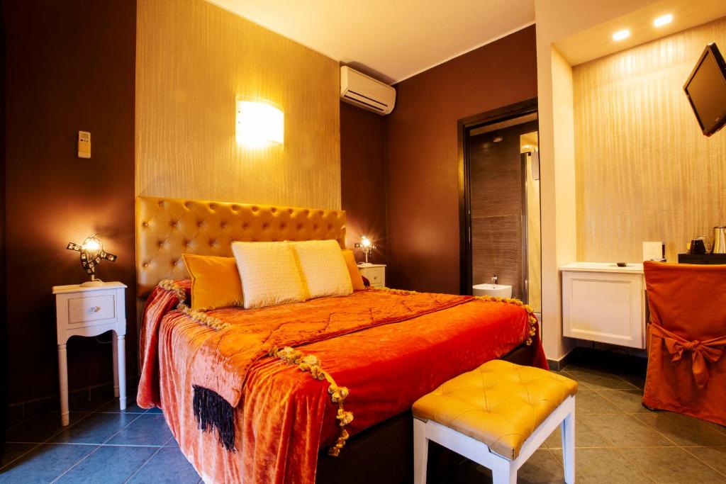 a bedroom with a large bed with orange sheets and yellow pillows at B&B Il Parco in Monterosso al Mare