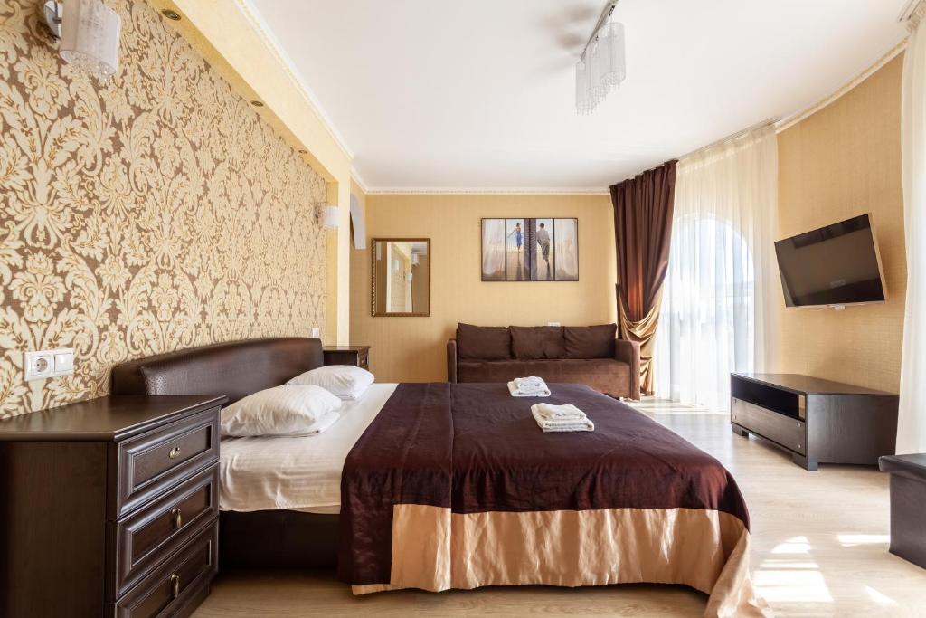 Habitación de hotel con cama y TV en Vinograd Hotel, en Sochi