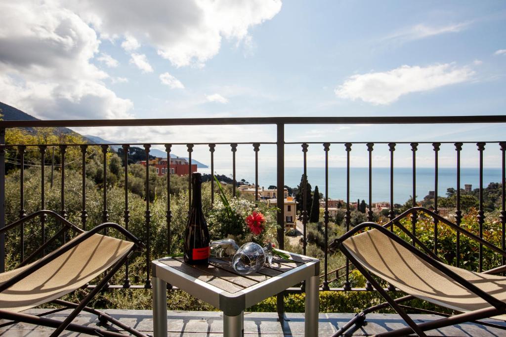 a table with a bottle of wine and two chairs on a balcony at B&B Il Parco in Monterosso al Mare