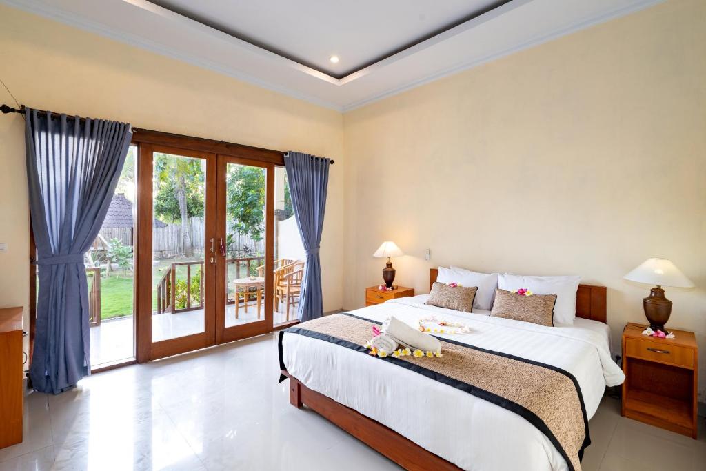 a bedroom with a large bed and a large window at Pemuntalan Guesthouse in Nusa Lembongan