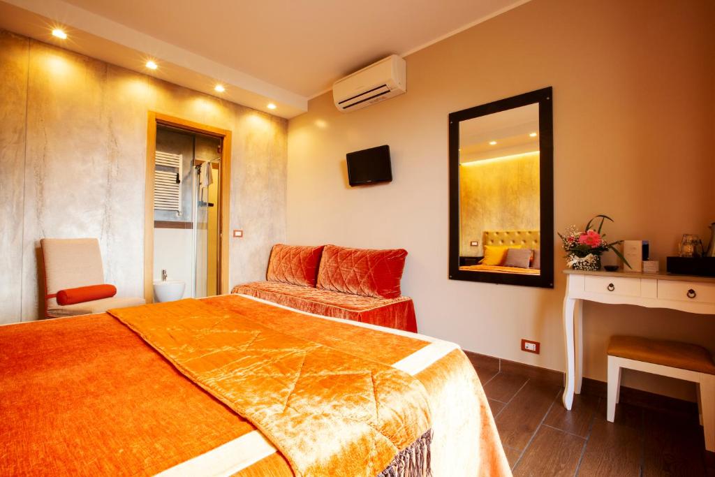 a bedroom with a bed and a chair and a mirror at B&B Il Parco in Monterosso al Mare