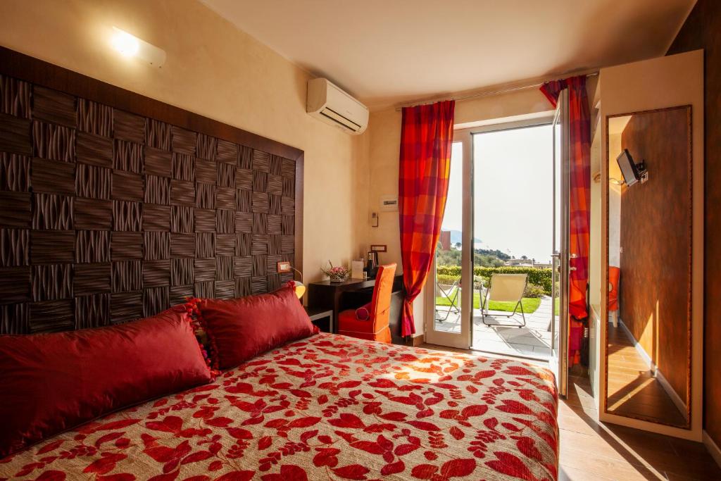 a bedroom with a large red bed and a balcony at B&B Il Parco in Monterosso al Mare