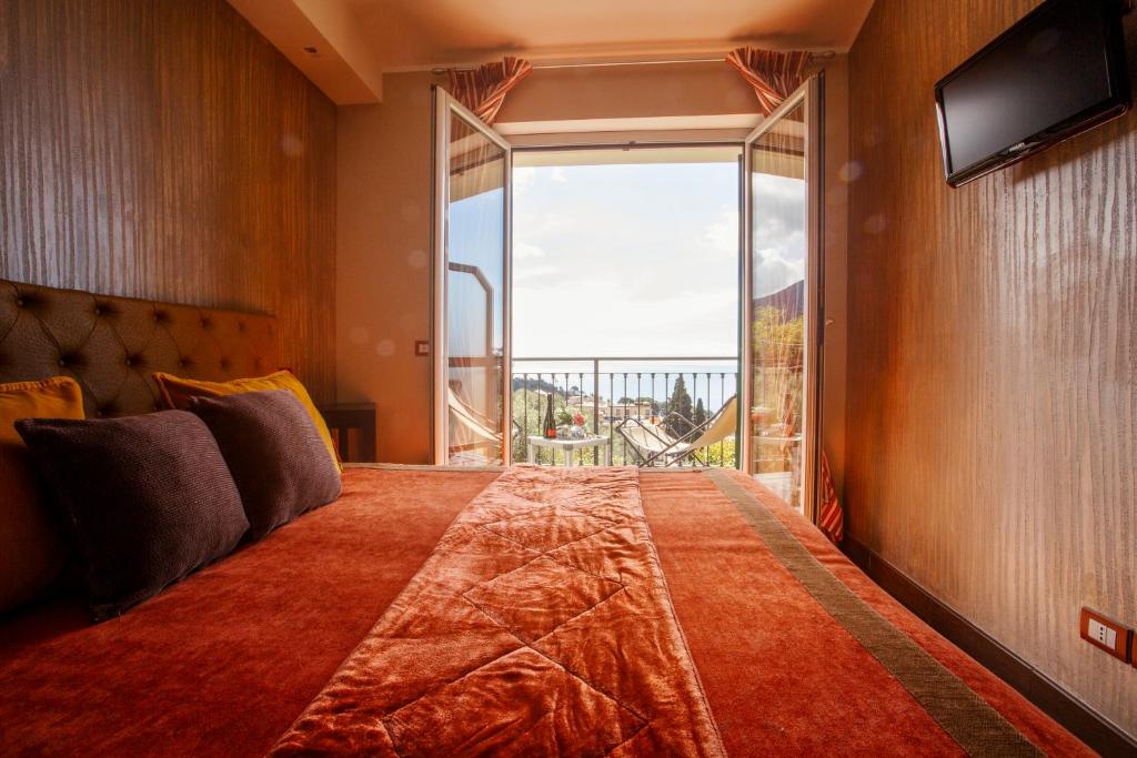 a bedroom with a large bed with a large window at B&B Il Parco in Monterosso al Mare