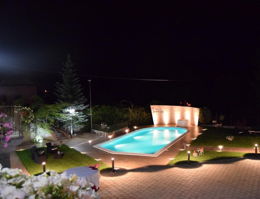 una piscina en un patio por la noche en La Quercia B&B en San Giovanni in Fiore