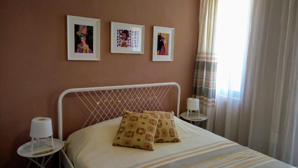 een slaapkamer met een bed met 2 tafels en een raam bij Ethno guest suite in Primorsko