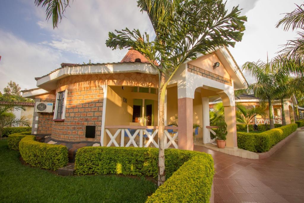 een huis met een palmboom ervoor bij Hotel Nyakoe Kisii in Kisii