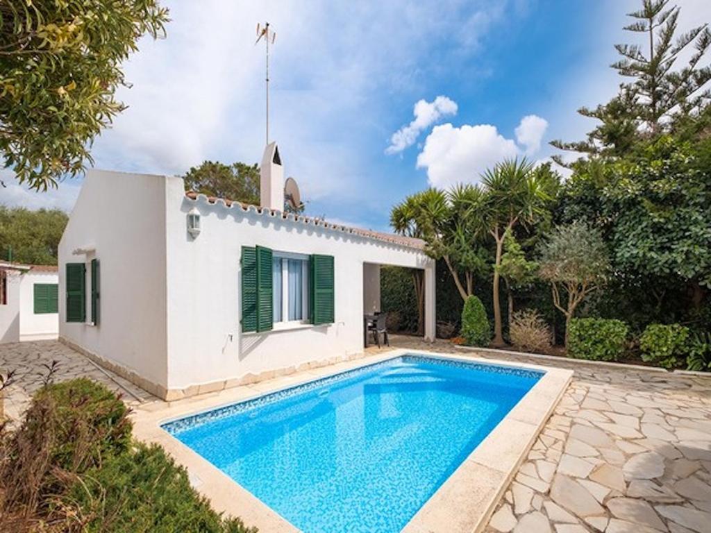 a villa with a swimming pool in front of a house at Chalet La Rosa in Cala Blanca