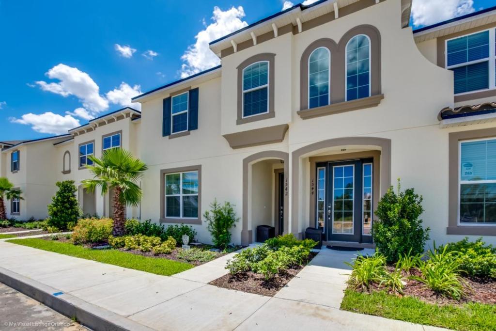 Une grande maison blanche avec volets bleus dans l'établissement Orlando Newest Resort Community Town Home Townhouse, à Orlando