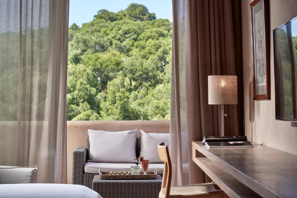 a room with a bed and a desk and a window at The Margi in Athens