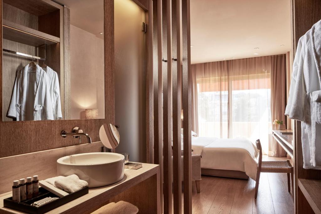 a bathroom with a sink and a bed in a room at The Margi in Athens