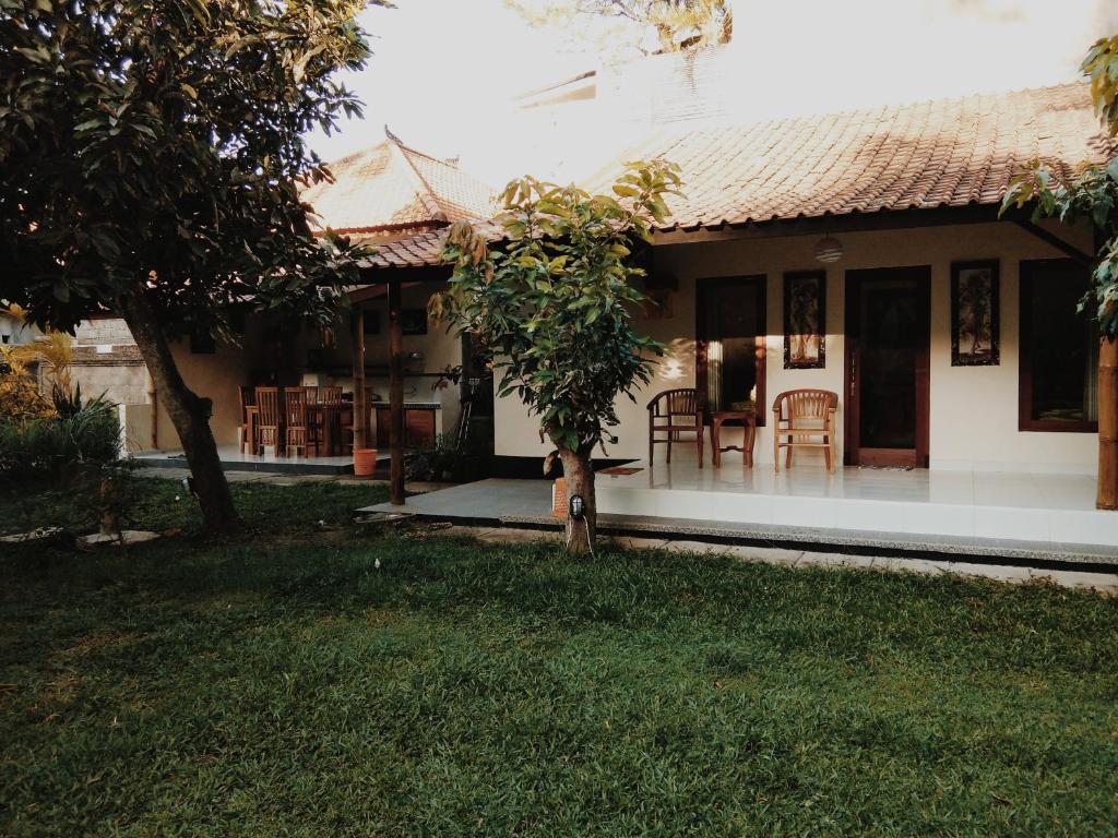 una casa con mesa y sillas en el patio en Honey Home Stay en Canggu