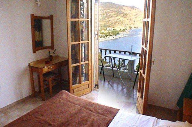 a bedroom with a bed and a view of a balcony at Diamont Studios in Agia Galini