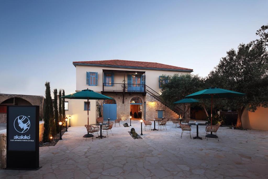 a patio with tables and umbrellas in front of a building at Polis 1907 by Louis Hotels in Polis Chrysochous