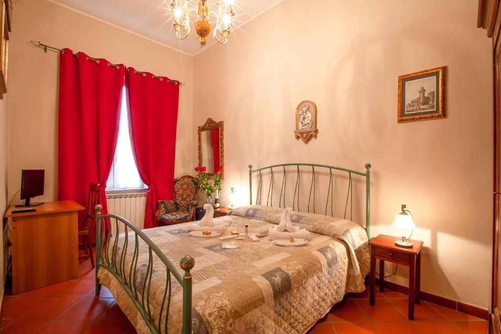 a bedroom with a bed with red curtains at La Rosa Di Firenze B&B in Florence