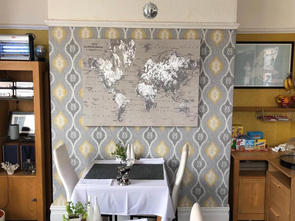 a table with a map of the world on a wall at Glen Guest House in Blackpool