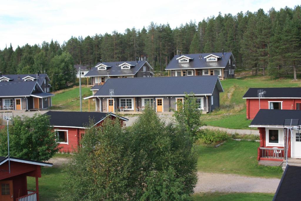 a group of houses on a hill with trees at Särkijärven Majat in Muonio