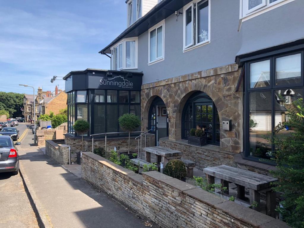 a restaurant with benches outside of a building at The Sunningdale in Bamburgh