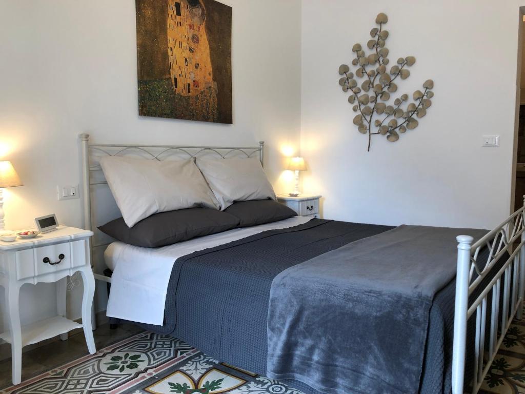 um quarto com uma cama e duas mesas de cabeceira em Petite Maison TA em Taranto