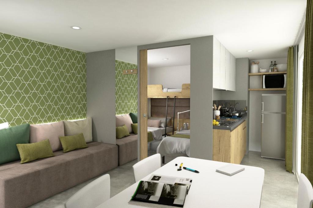ein Wohnzimmer und eine Küche mit einem Sofa und einem Tisch in der Unterkunft Casapini Premium Mobile Home in Poreč