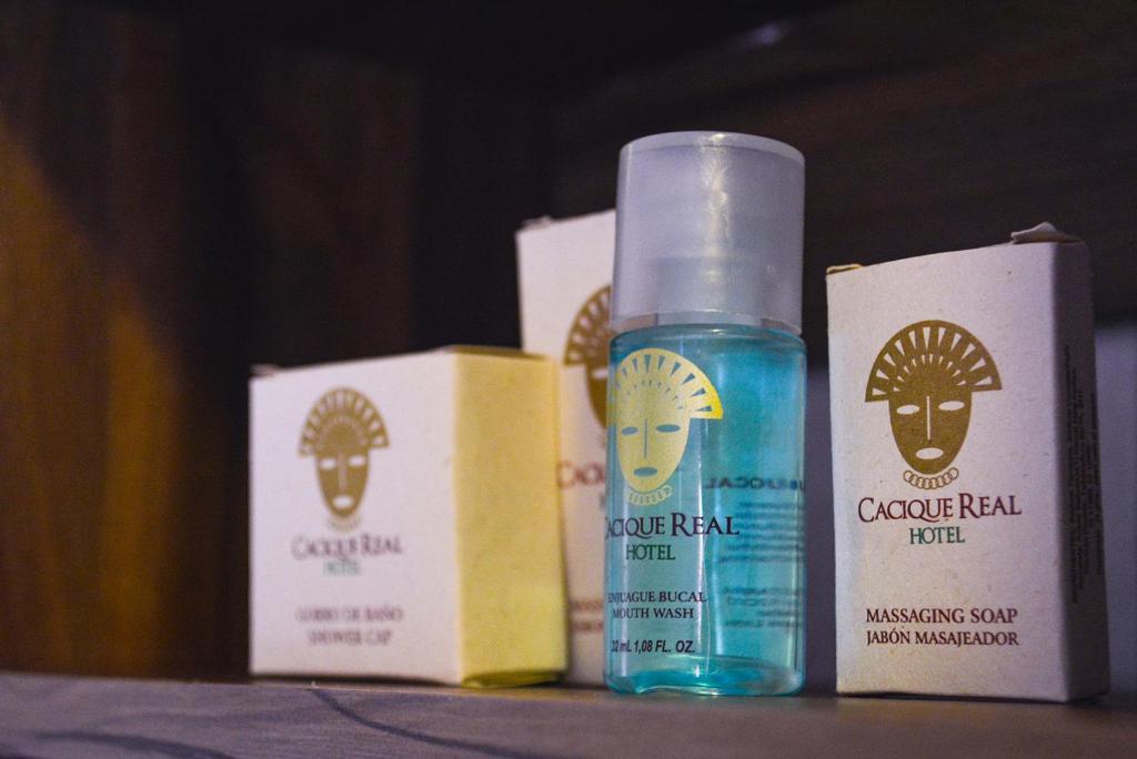 a bottle of hair products sitting next to boxes at Hotel Cacique Real in Zipaquirá