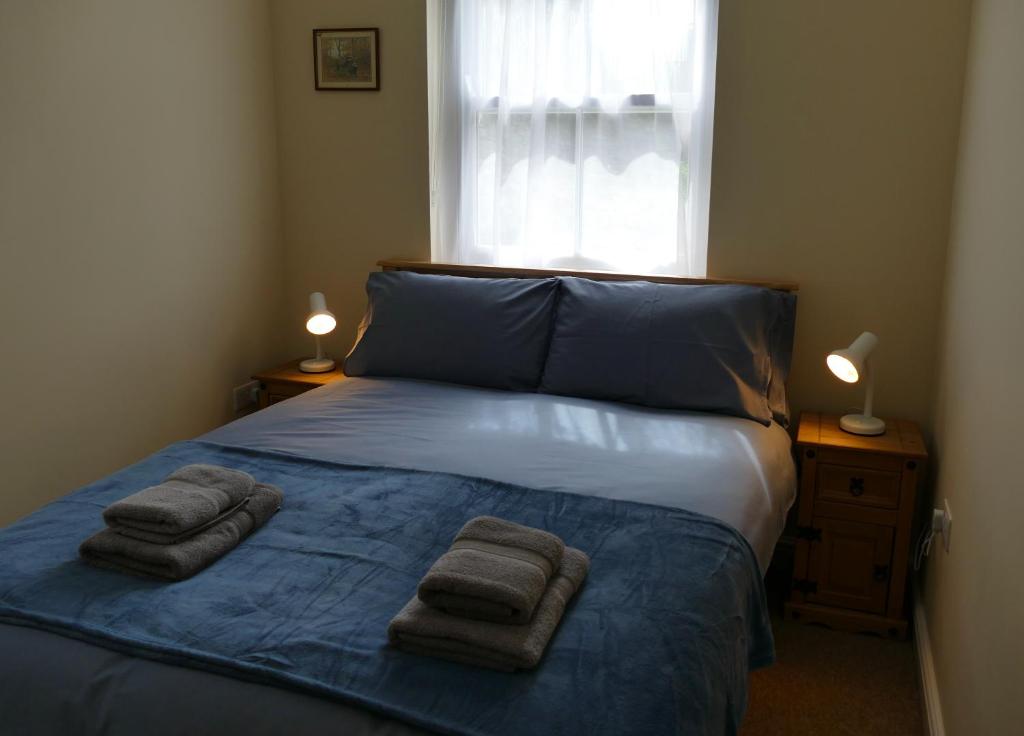 a bedroom with a bed with towels on it at 2 Bell Street in Talgarth