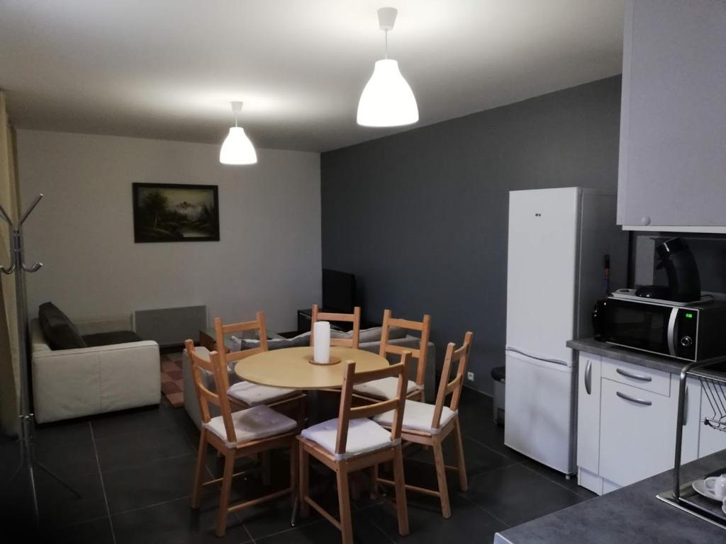 - une cuisine et une salle à manger avec une table et des chaises dans l'établissement Maison Duplex & Appartement sur cour, à La Ferté-Gaucher