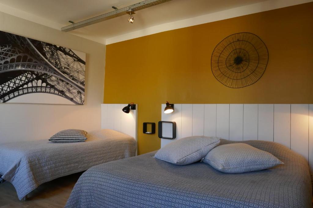 sypialnia z 2 łóżkami i żółtą ścianą w obiekcie Le Sommeil des Fées w mieście Saint-Rémy-de-Provence