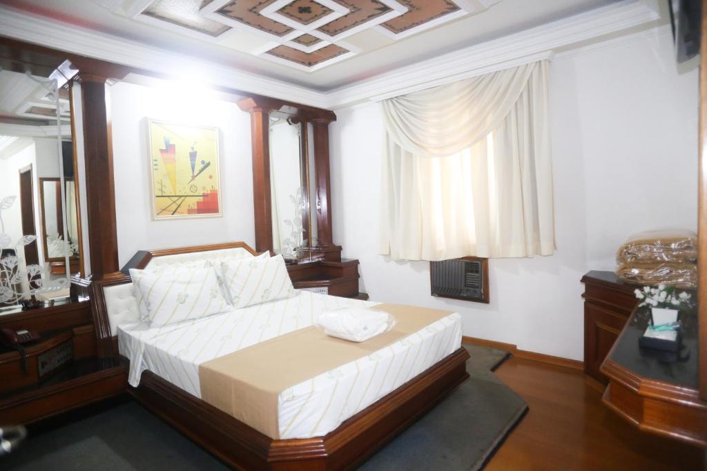 1 dormitorio con 1 cama grande con sábanas blancas en Maison Florense Hotel, en São Paulo