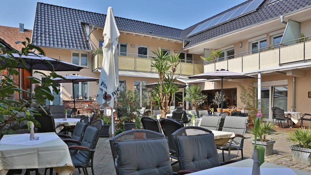 eine Terrasse eines Restaurants mit Tischen und Stühlen in der Unterkunft Burgers Hotel in Kippenheim