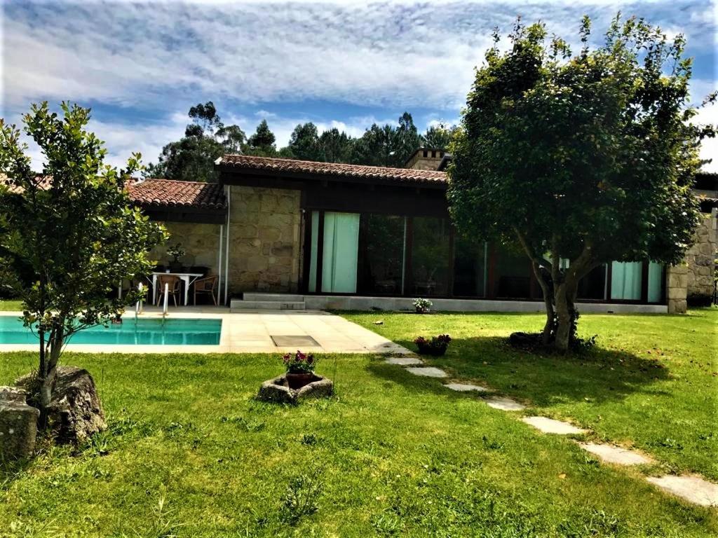 a house with a yard with a swimming pool at casa da pedra in Tomiño