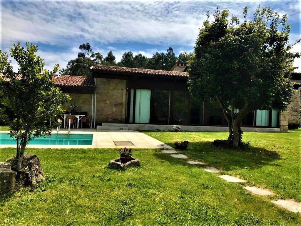 una casa con patio con piscina en casa da pedra, en Tomiño