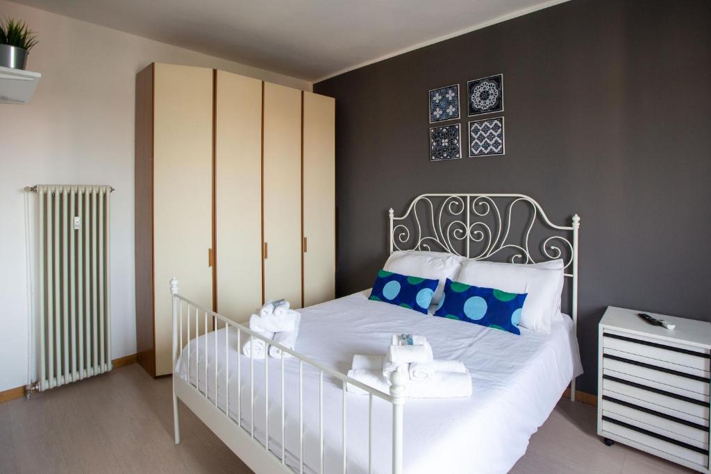 una camera da letto con un letto bianco con cuscini blu di Apartment - Sacchini 16 a Milano