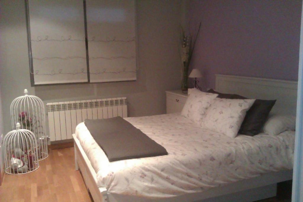 a bedroom with a bed and two bird cages at APARTAMENTO EN CAMPO DE GOLF in Cirueña