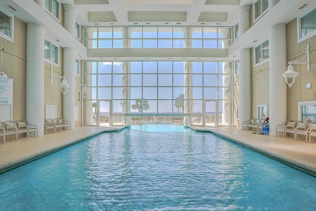 a swimming pool in a building with a large window at Majestic Sun in Destin