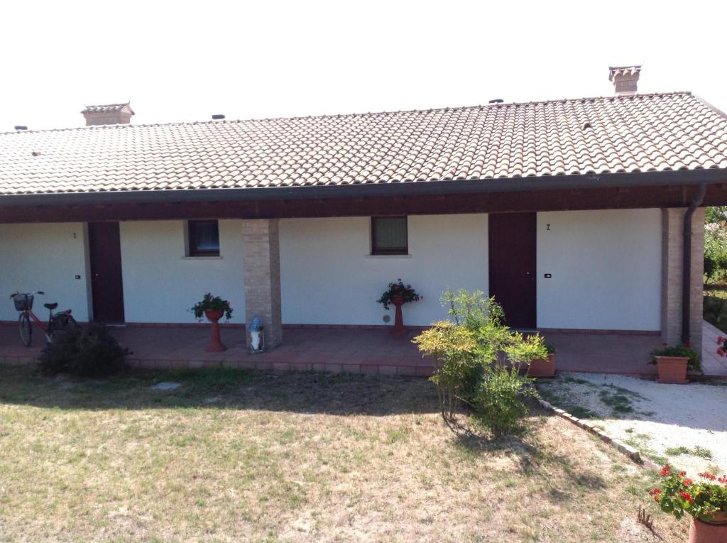 a small white house with a large porch at Agriresidence San Pietro in Bibione