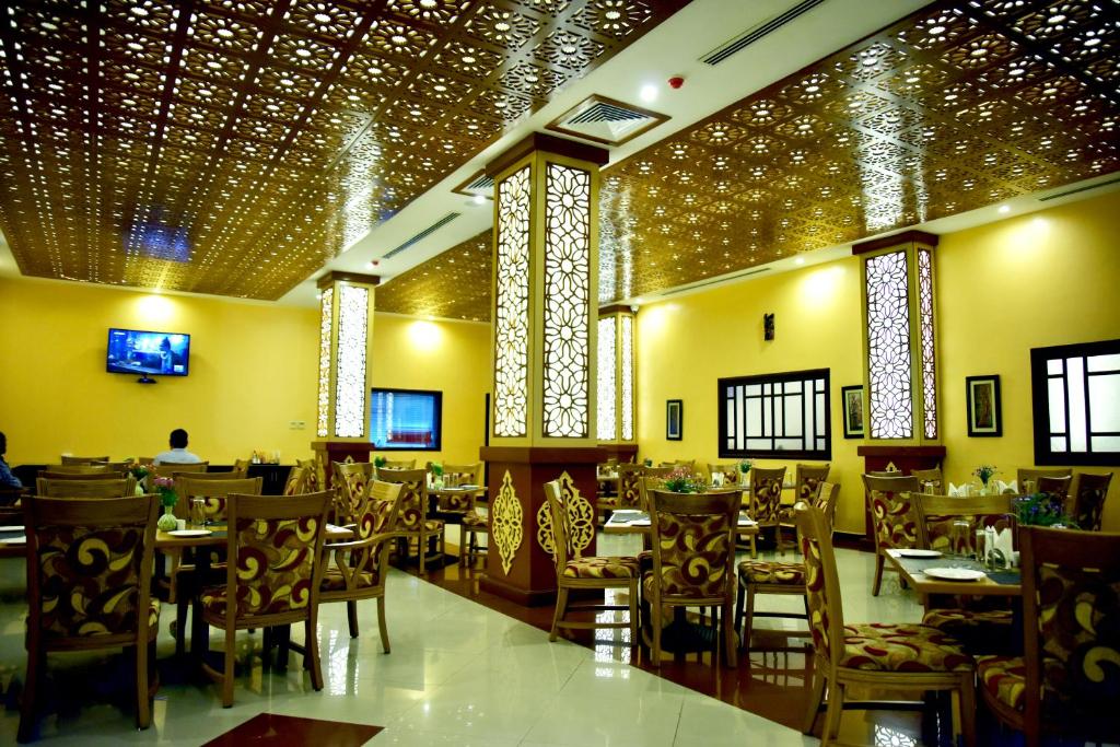 a dining room with tables and chairs and lights at Hotel Blue Sapphire in Dar es Salaam