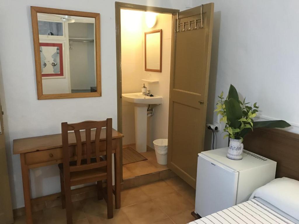 a small bathroom with a table and a chair at Casa de Huespedes la Peña in Ibiza Town