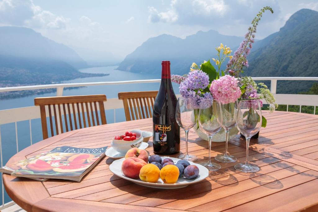 een tafel met een fles wijn en een fruitschaal bij Villa Ponti Bellavista in Bellagio