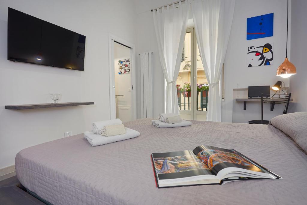 ein Schlafzimmer mit einem Bett mit einem Buch darauf in der Unterkunft Better & Better in Palermo