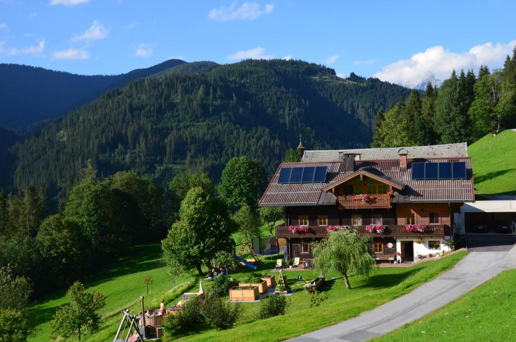 a house with solar panels on it in the mountains at Bio-Bauernhof Nichlgut in Eben im Pongau