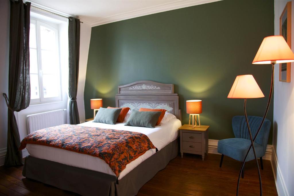 a bedroom with a bed and a blue chair at La bohème - Chambres d’hôtes in Senlis