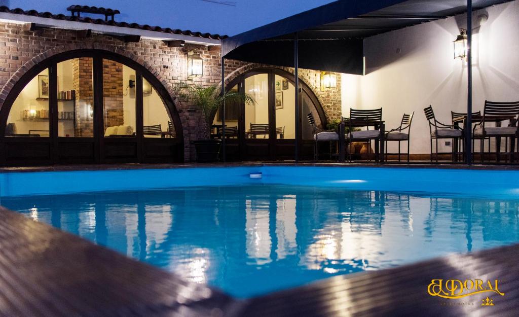 una piscina con sillas y mesas en un edificio en Apart Hotel El Doral, en Lima
