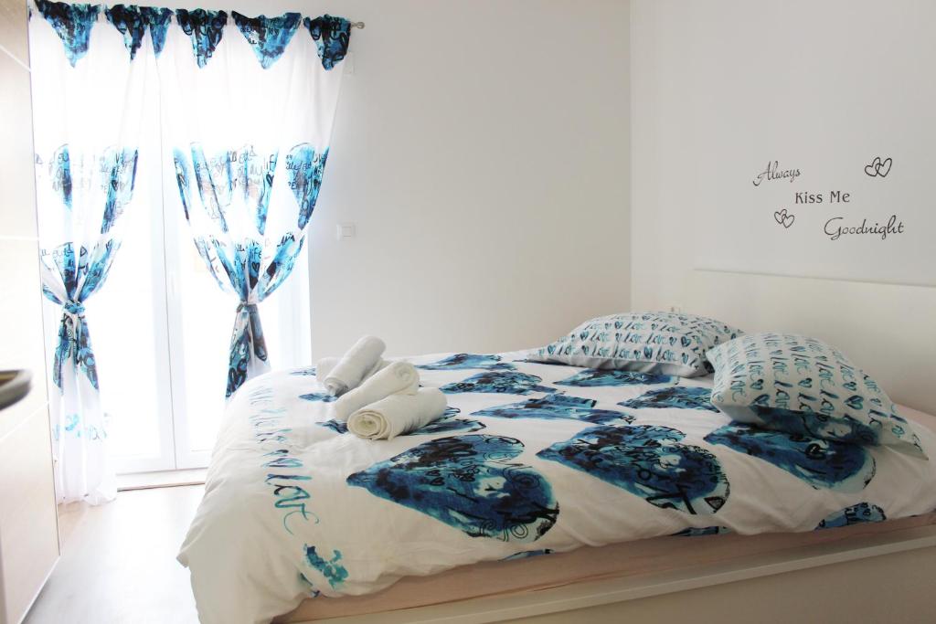 - un lit avec des draps et des oreillers bleus et blancs dans l'établissement Apartment Pino, à Pučišća