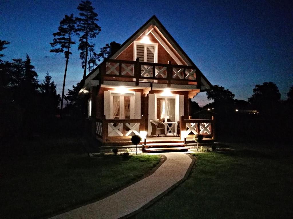 a small house with lights on the front of it at Drewniany domek nad Miedwiem in Morzyczyn