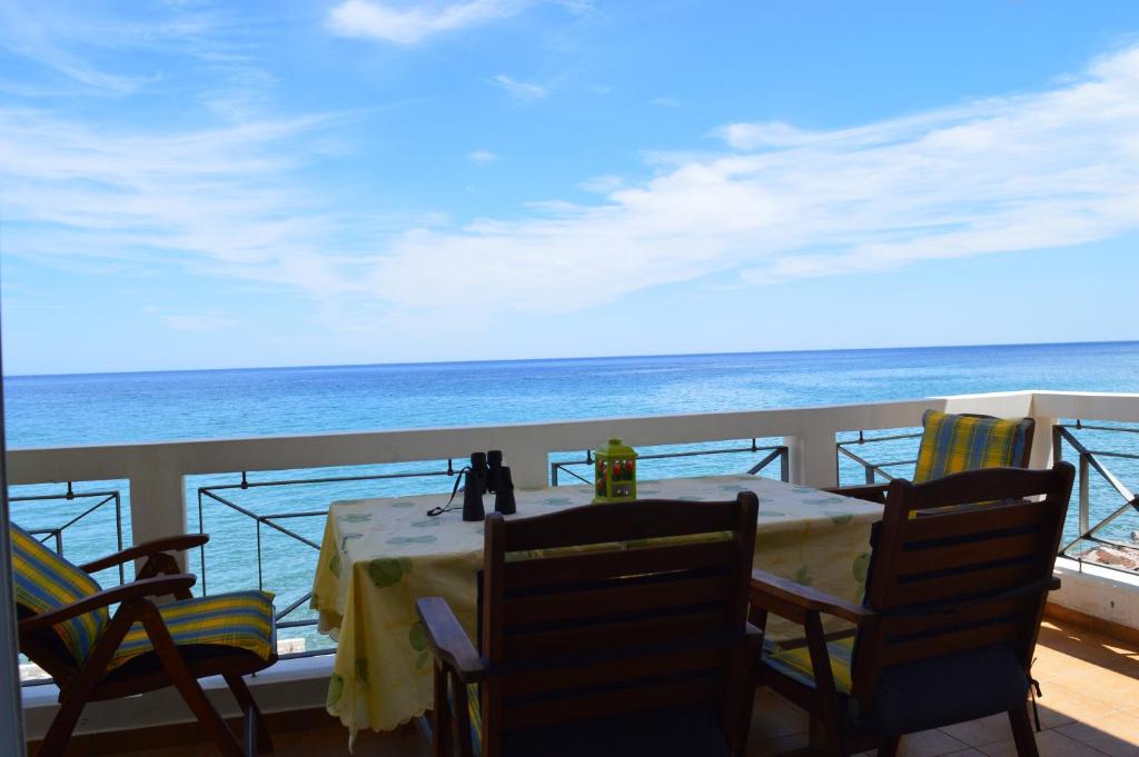 una mesa y sillas en un balcón con vistas al océano en Aegean View, en Platána